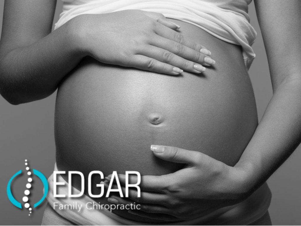 Pregnant woman holding her stomach.