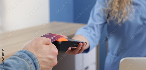 A man paying for chiropractic care, tapping his credit or debit.