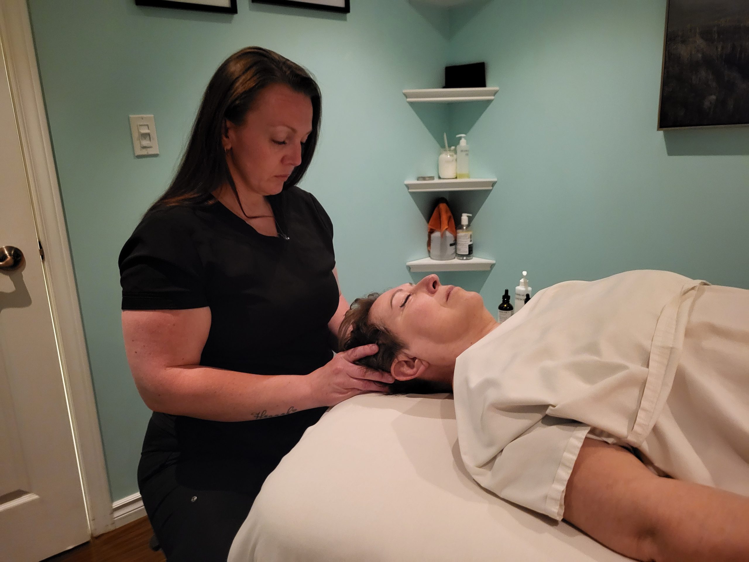 Chiropractor providing massage therapy to a client head.