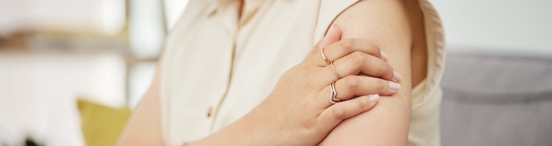 A woman holding her arm, in pain or discomfort.