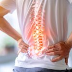 Man holding his lower back with highlighted spine illustrating low back pain and spinal discomfort.