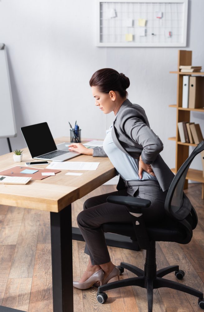 woman showing back discomfort from sitting
